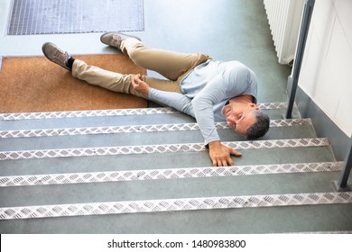 Mature Man Lying On Staircase After Slip And Fall Accident