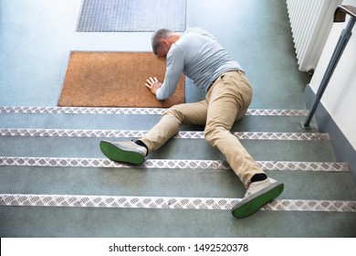 Mature Man Lying On Staircase After Slip And Fall Accident