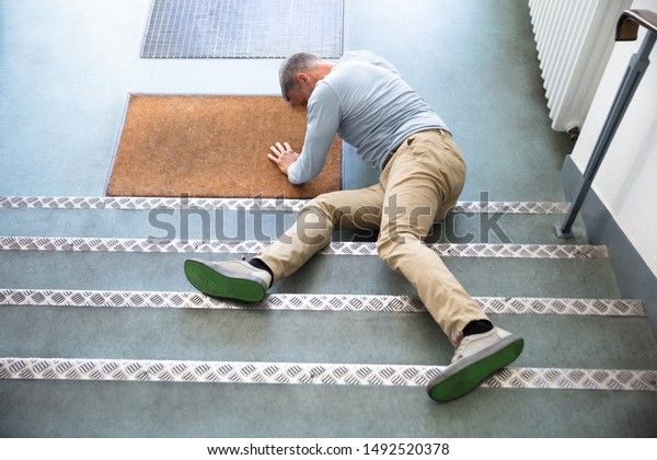 Mature Man Lying On Staircase After Slip And\
Fall Accident