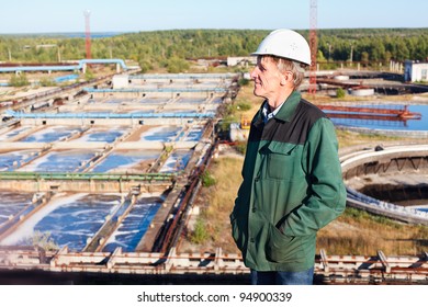 Mature Man Manual Worker In White Hardhat Near Sewage Treatment Basin