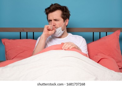 Mature man in medical mask coughing because of flu sitting alone in the bed. - Powered by Shutterstock