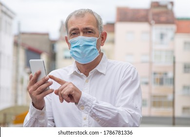 Mature Man With Medical Mask Using Mobile Phone