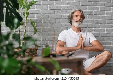 Mature Man Meditating At Home