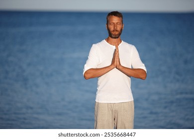 Mature, man and meditation with yoga at ocean for mindfulness healing, spiritual peace and performance. Male person, zen and water with chakra zen for mental health, mindset balance and nature aura - Powered by Shutterstock