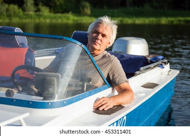 Mature Man On Driving Motor Boat.