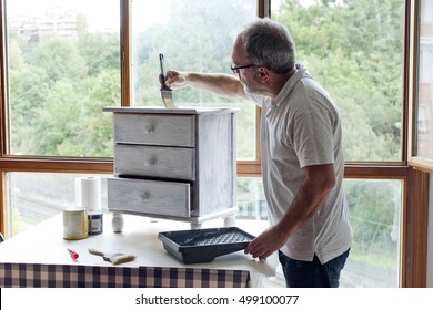 Mature Man Painting White Furniture