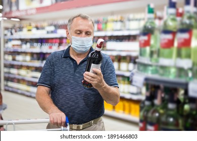 Mature Man In Protective Mask Buying Bottle Of Wine In Store With Alcohol Drinks