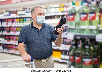 Mature Man In Protective Mask Buying Bottle Of Wine In Store With Alcohol Drinks