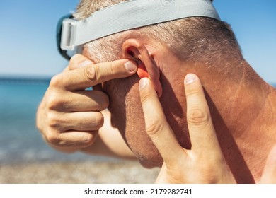 Mature Man Putting Silicone Ear Plugs, Surfers Earplugs, Swim Plugs