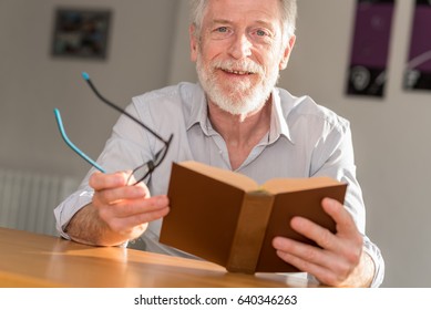 Mature Man Reading A Book At Home