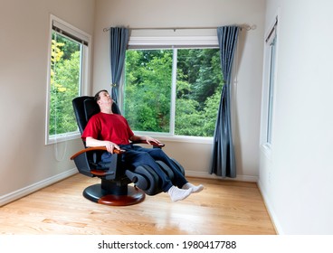 Mature Man Relaxing In Home Massage Chair For Pain Relief In Back And Legs  