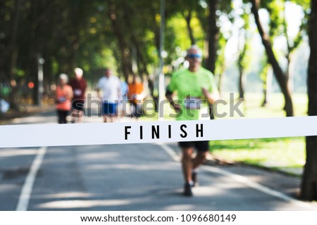 Mature man running towards the finish line