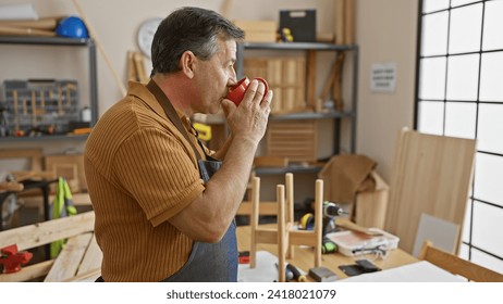 Mature man sipping coffee in a well-equipped carpentry workshop, representing a craftsman's break time. - Powered by Shutterstock