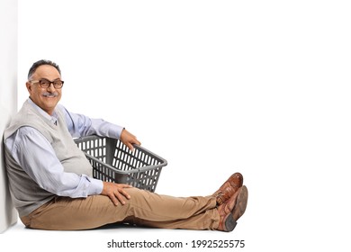 Mature Man Sitting And Holding An Empty Laundry Basket Isolated On White Background