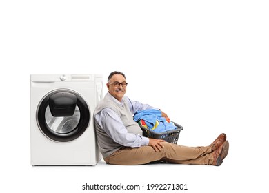 Mature man sitting with a laundry basket and leaning on a washing machine isolated on white background - Powered by Shutterstock