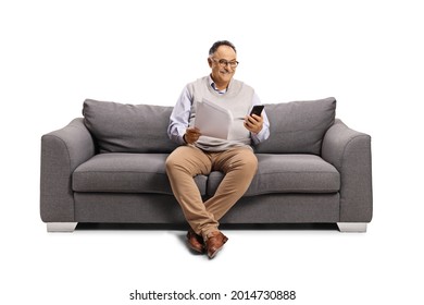 Mature Man Sitting On A Sofa With A Mobile Phone And A Paper Document Isolated On White Background