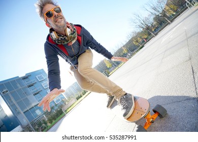 Mature Man Skateboarding In The Street