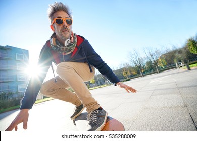 Mature Man Skateboarding In The Street