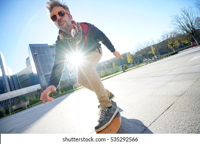 Mature Man Skateboarding In The Street