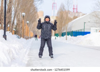 Mature Man Skating On The Ice Track In The Park.