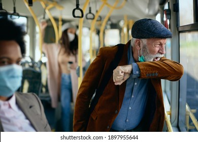 Mature man sneezing into elbow while traveling by public transport.  - Powered by Shutterstock