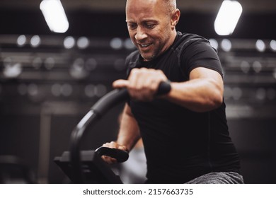 Mature man in sportswear exerting himself while riding an exercise bike during a workout at the gym - Shutterstock ID 2157663735