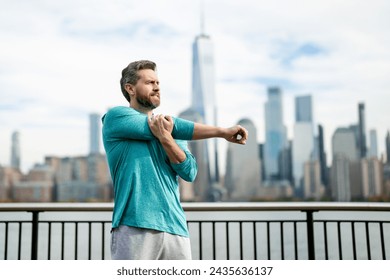 Mature man in sportswear stretching his arms outside. Athletic Mature Fit Man Doing Exercises in City outdoor. Happy man workout in New York city. Sport, fitness and exercise. - Powered by Shutterstock