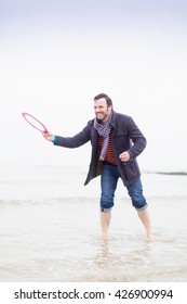 Mature Man Standing In Sea, Holding Frisbee