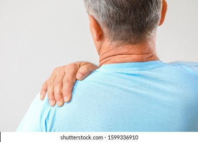 Mature Man Suffering From Pain In Shoulder On White Background