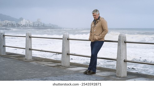 Mature man, thinking and outdoor by ocean with relax, planning and reflection for break on weekend. Male person, mental health and wellness by seaside, beach or water for ideas, memory or mindfulness - Powered by Shutterstock