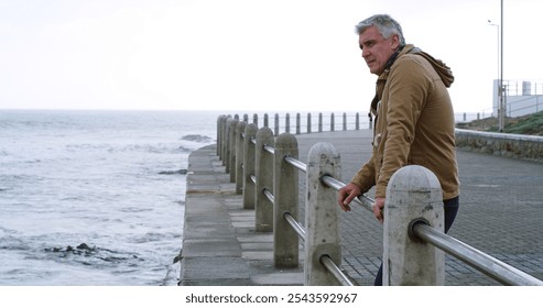 Mature man, thinking and stress by beach with outdoor, planning or reflection for break on weekend. Male person, mental health and wellness by seaside, ocean or water for space, memory or mindfulness - Powered by Shutterstock