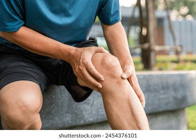 Mature man tired and leg pain during jogging at nature park. Runner has sore knees because he has been running for too long. Exercising until the injury. Training athlete work out at outdoor. - Powered by Shutterstock