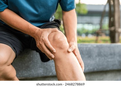 Mature man tired and leg pain during jogging at nature park. Runner has sore knees because he has been running for too long. Exercising until the injury. Training athlete work out at outdoor. - Powered by Shutterstock