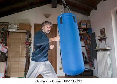 Mature Man Training With A Punching Bag At His Home