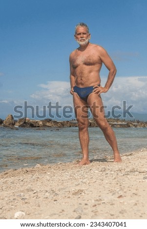 mature man in the tropical beach with blue speedo