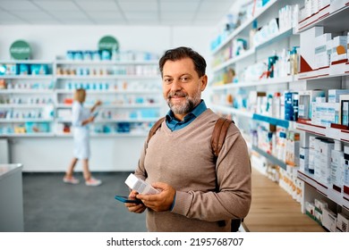 Mature man using cell phone wile buying in drugstore and looking at camera. - Powered by Shutterstock