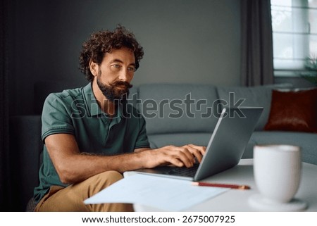 Mature man using laptop while working at home. 