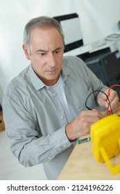 A Mature Man Using Multimeter