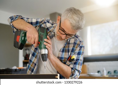 Mature Man Using Power Drill At Home