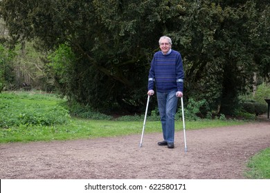 Mature Man Walking With Crutches, Exercise Is An Important Part Of Recovery After Hip And Knee Replacement Surgery Or Injury
