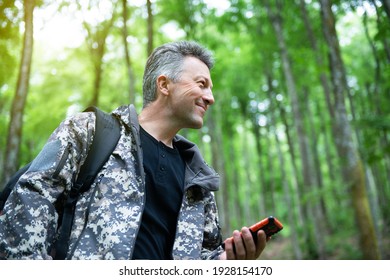 Mature Man Walking And Hiking In Mountain Forest And Using Mobile Phone. Male Spring Outdoor Portrait. 