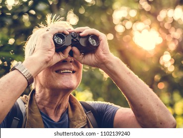 Mature man watching birds through binoculars - Powered by Shutterstock