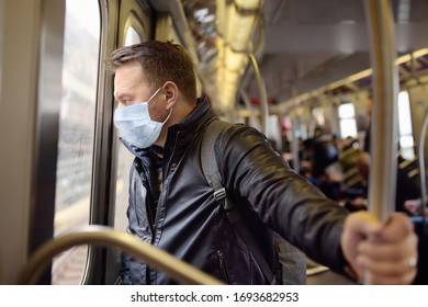 Mature man wearing disposable medical face mask in car of the subway in New York during coronavirus outbreak. Safety in a public place while epidemic of covid-19.
