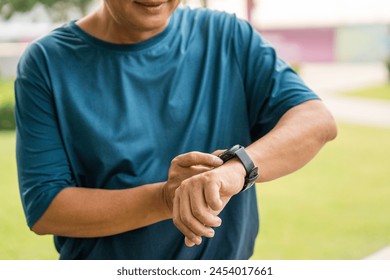 Mature man wearing sportswear using Smart Watch Showing Heart Rate Monitor. Old man with Technology for health and sport mode. Exercise and take statistics to develop your potential - Powered by Shutterstock