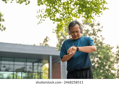 Mature man wearing sportswear using Smart Watch Showing Heart Rate Monitor. Old man with Technology for health and sport mode. Exercise and take statistics to develop your potential - Powered by Shutterstock