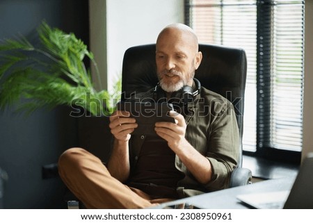 Mature man without job indulging in gaming addiction, spending his life immersed in virtual world of online games on laptop. Concept of idleness and unproductivity. High quality photo