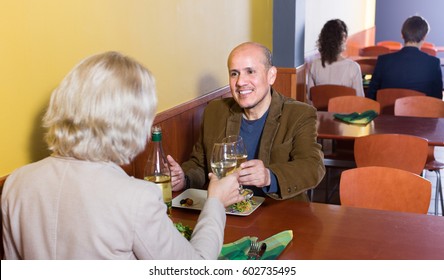 Mature man and woman 55s spending time together in restaurant