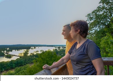 Mature Man And Woman Looking At Missouri River Flood Plain At Sunset