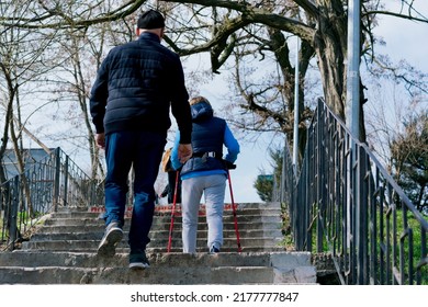 Mature Man And Woman With Walking Canes Going Up The Stairs Outdoor. Action. Nordic. Male. Healthy. Upstairs. Achievement. Travel. Age. Direction. Fitness. Enjoyment. Forward. Elderly. Jacket. Autumn