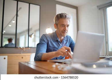 Mature man working from contemporary home - Shutterstock ID 1364788520